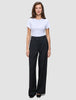 En kvinne iført en hvit T-skjorte og svarte Serene Pants Wide Black-bukser med høy midje og vide ben.