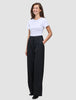 En kvinne kledd i en hvit T-skjorte og svarte Serene Pants Wide Black-bukser med høy midje og vide ben.