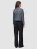 En person sett bakfra, kledd i en grå blazer og svarte Serene Pants Wide Black.