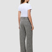 En kvinne sett bakfra, kledd i en hvit T-skjorte og grå Women Ashryn Pants Wide Domino Herringbone-bukser med vide ben.