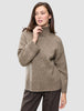 En kvinne som har på seg en Women Chunky Soft Wool Knit Turtleneck Taupe Melange-genser.