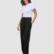 En kvinne iført en hvit T-skjorte og Women GO2 Pants Straight Black i klassisk skandinavisk design.