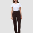 En kvinne har på seg en hvit T-skjorte og mørkebrune Women GO2 Pants Straight Mocha med rett snitt.