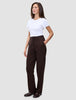 En kvinne i en hvit T-skjorte og et par Women GO2 Pants Straight i fargen mocha, med hånden i lommen.
