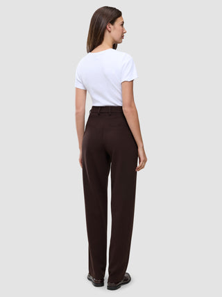 En kvinne sett bakfra, kledd i en hvit T-skjorte og Women GO2 Pants Straight Mocha med rett snitt.
