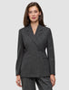 En kvinne har på seg en Women Nara Blazer Fitted Black Check, en tettsittende blazer med dobbeltknapping i svart-hvitt rutemønster.