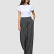 En kvinne iført en hvit T-skjorte og Women Nara Pants Wide Black Check med 360°-stretch.
