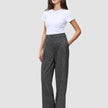 En kvinne iført en hvit T-skjorte og Women Nara Pants Wide Black Check med mørkegrått rutemønster.