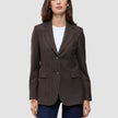 En kvinne har på seg en Women Serene Blazer Regular Walnut Herringbone over en hvit T-skjorte og blå jeans.