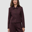En kvinne iført en Women Serene Short Jacket Berry Pinstripe, med et minimalistisk design og knappelukking.