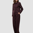 En kvinne kledd i en minimalistisk Women Serene Short Jacket Berry Pinstripe og matchende bukser med vide ben.