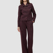 En kvinne iført en Women Serene Short Jacket Berry Pinstripe sammen med matchende bukser med vide ben.