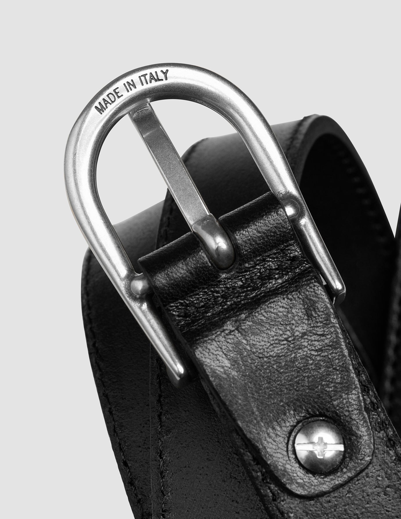Tynn lærbelte for kvinner, sølv og svart, med en sølvspenne med inngravert «Made in Italy».