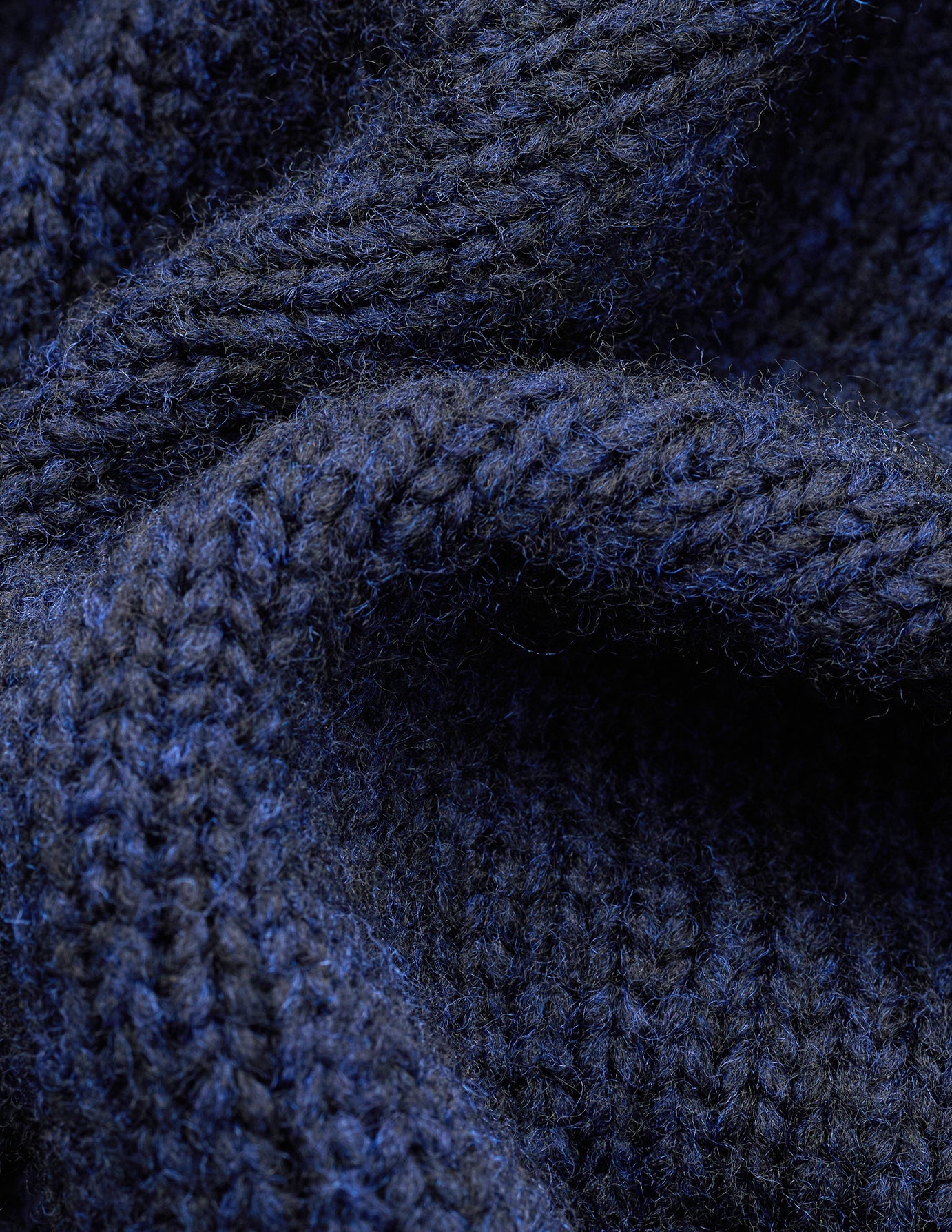 Nærbilde av en tykk, mørkeblå genser i merinoull: Chunky Soft Wool Knit Crewneck Dark Navy Melange.