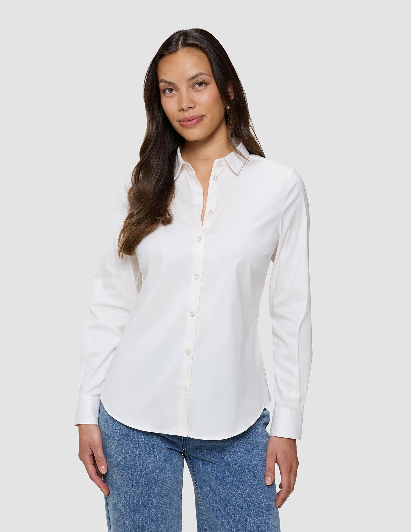 Kvinne iført en Women’s Oxford Shirt White Orchid Slim, som er stappet inn i blå jeans.