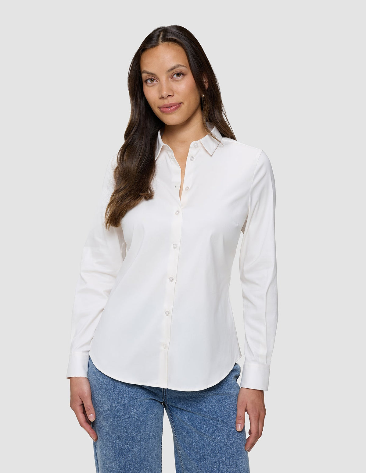 Kvinne iført en Women’s Oxford Shirt White Orchid Slim, som er stappet inn i blå jeans.