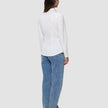 En kvinne sett bakfra, kledd i en Women’s Oxford Shirt White Orchid Slim og blå jeans.