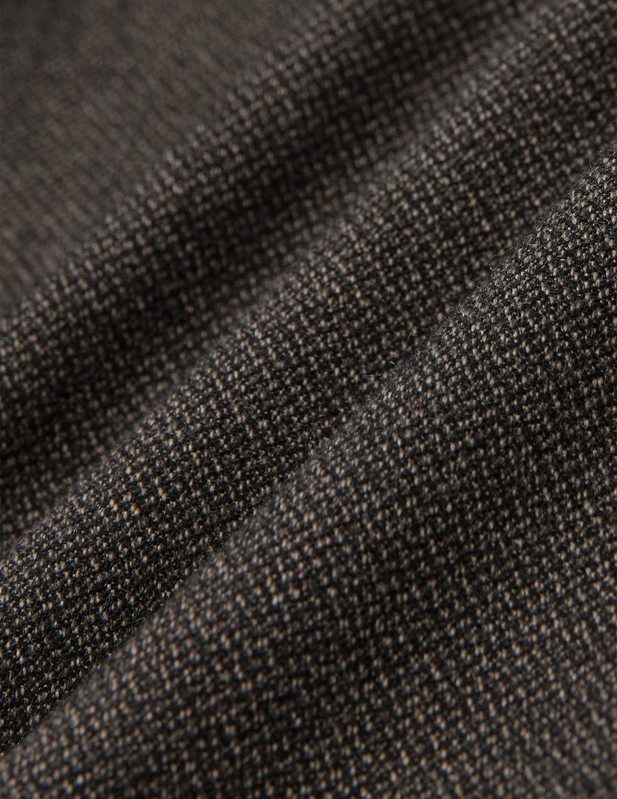 Nærbilde av Atelier Pants Relaxed Dark Brown i brettet mørkebrunt stoff med et strukturert, brutt twill-vev.