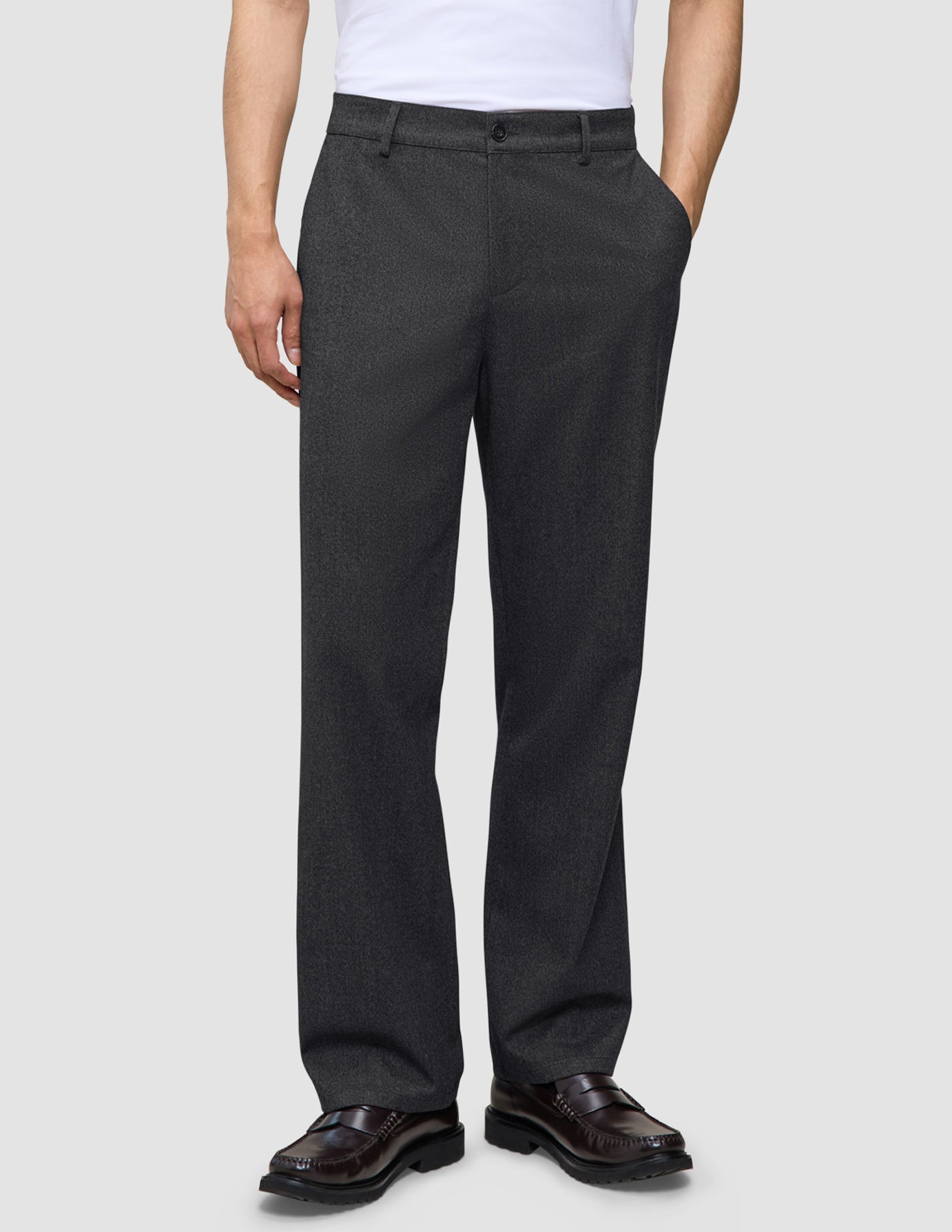 Atelier-bukser i avslappet passform, mørkegrå i brutt twill, kombinert med en hvit T-skjorte og brune loafers i skinn.