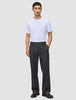 En mann i hvit T-skjorte, Atelier Pants Relaxed i mørkegrått og mørke loafers – et levende eksempel på skandinavisk design.