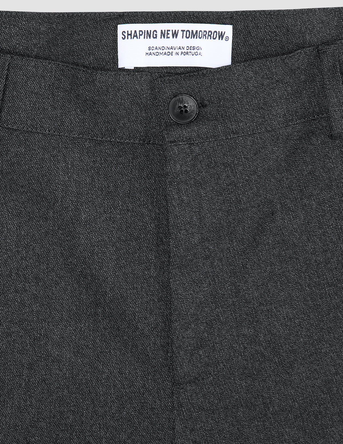 Mørkegrå Atelier-bukse i brutt twill, med en svart knapp og SHAPING NEW TOMORROW-merke.
