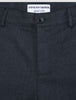 Nærbilde av de mørkeblå Atelier Pants Relaxed-buksene, som viser stoffet i brutt twill, knappelukking og innvendig merkelapp.