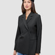 En kvinne som har på seg en svart Women’s Avira Blazer Black med dobbeltradet snitt og en svart beret.