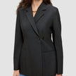 En kvinne som har på seg en svart, dobbeltradet Women’s Avira Blazer-blazer over blå jeans.