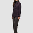 En kvinne har på seg en burgunderfarget Women’s Avira Blazer Burgundy Berry over en grå turtleneck og mørke bukser fra Dansk Design.