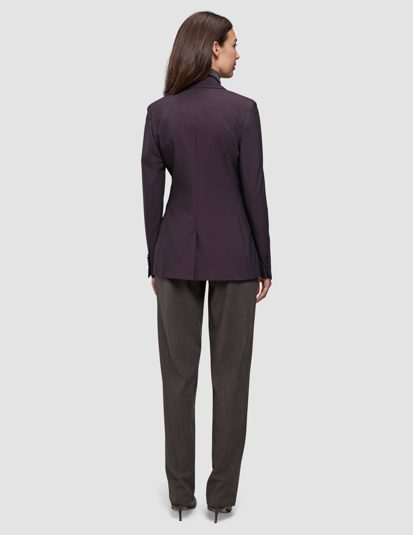Bakfra-bilde av en kvinne som har på seg en mørk burgunderfarget Women’s Avira Blazer Burgundy Berry og grå bukser.