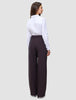 En kvinne kledd i en hvit skjorte med knapper og et par Women’s Avira Pants Wide Burgundy Berry-bukser med høy midje.