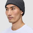 En person som har på seg en Beanie Dark Grey i mørkegrått, ribbestrikket skandinavisk design.