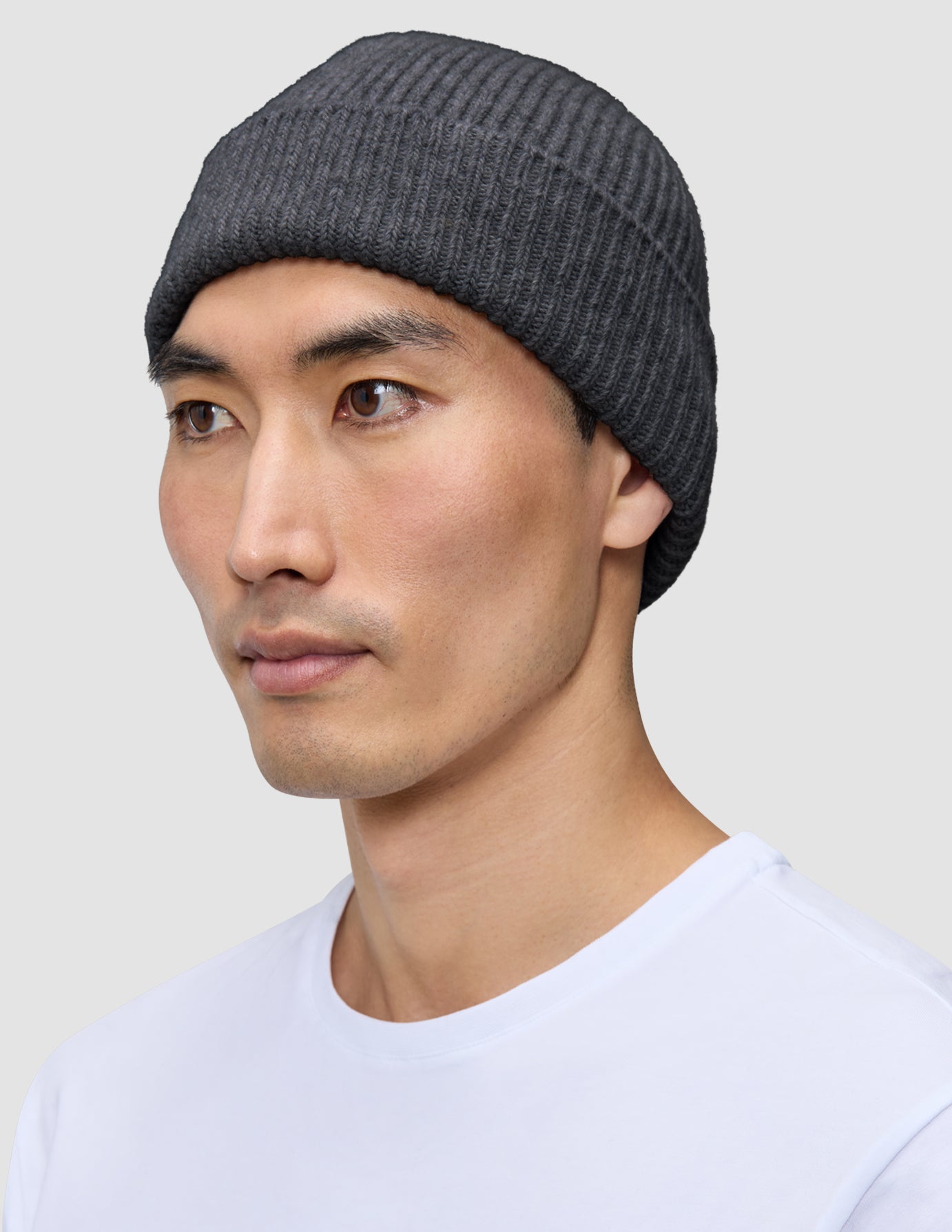 En person som har på seg en Beanie Dark Grey i mørkegrått, ribbestrikket skandinavisk design.