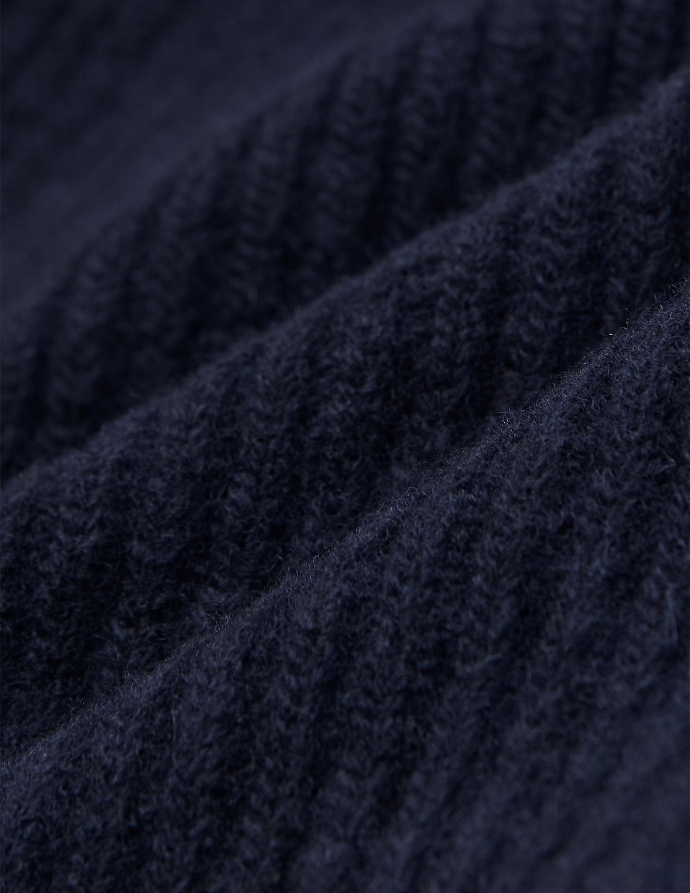 Nærbilde av en marineblå Wool Beanie Navy-lue i ribbestrikket merinoull.