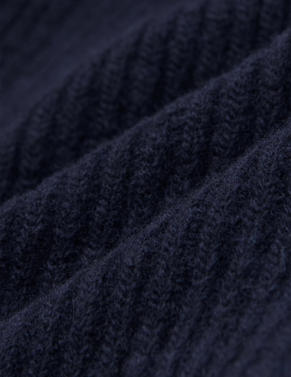 Nærbilde av en marineblå Wool Beanie Navy-lue i ribbestrikket merinoull.