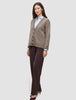 En kvinne som har på seg en Women’s Chunky Soft Wool Knit Cardigan Taupe Melange over en lyseblå skjorte og mørke bukser.