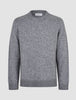 Grovstrikket, myk ullgenser med rund hals i fargen Glacier Grey, i grovstrikket, myk ull med ribbestrikkede mansjetter og nederkant, med nordisk design.