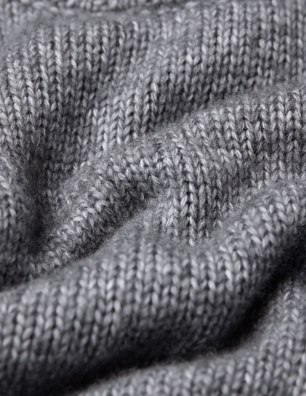 Nærbilde av en grå Chunky Soft Wool Knit Crewneck Glacier Grey-genser med en grov, myk strikketekstur.