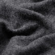 Nærbilde av en brettet, mørkegrå Double Layer Wool Overshirt Regular Dark Grey-skjorte i et stoff med en lodden tekstur.