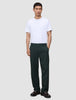 En person i en hvit T-skjorte, mørkegrønne Ease Pants Relaxed Fit Northern Pine og mørke loafers.