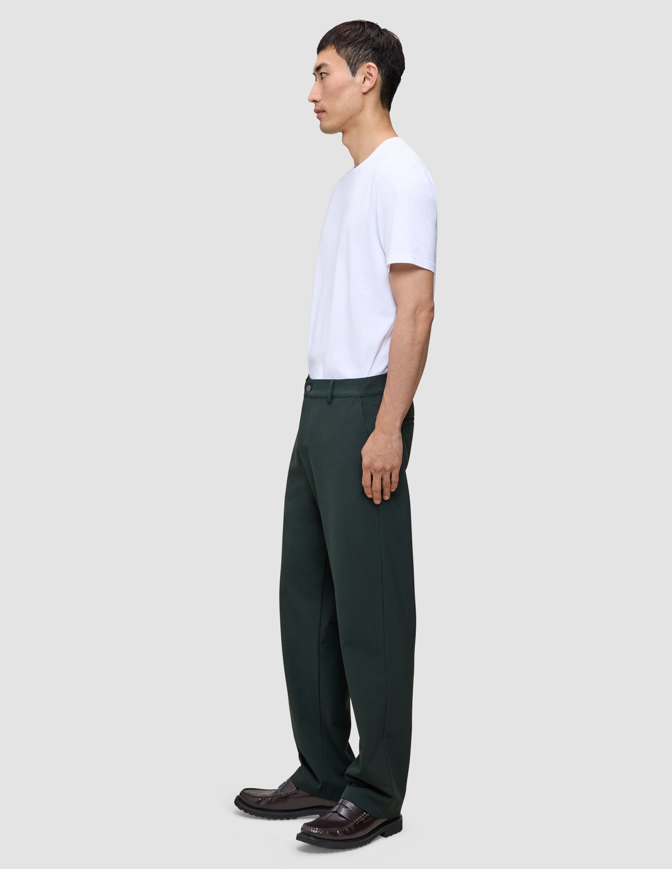 En person i en hvit T-skjorte og Northern Pine Ease Pants Relaxed Fit, med en avslappet passform og 360°-stretch.