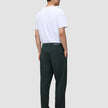 En mann sett bakfra, kledd i en hvit T-skjorte og mørkegrønne Ease Pants Relaxed Fit Northern Pine med 360°-stretch.