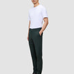 En person i en hvit T-skjorte, Ease Pants Slim Northern Pine og mørke lærstøvler i skandinavisk design.