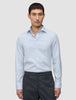 En mann kledd i en Elevated Shirt Regular Classic Blue Striped – en lyseblå og hvit stripete bomullsskjorte – og grå bukser.
