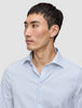 Mann iført en Elevated Shirt Regular Classic Blue Striped – en lysblå og hvit Pima-bomullsskjorte med knapper og tynne striper.