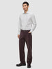 En mann kledd i en Elevated Shirt Regular Light Grey Striped-skjorte og mørkebrune bukser.