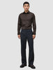 En mann kledd i en mørkebrun Elevated Shirt Slim, mørke bukser og mørke skinnsko.