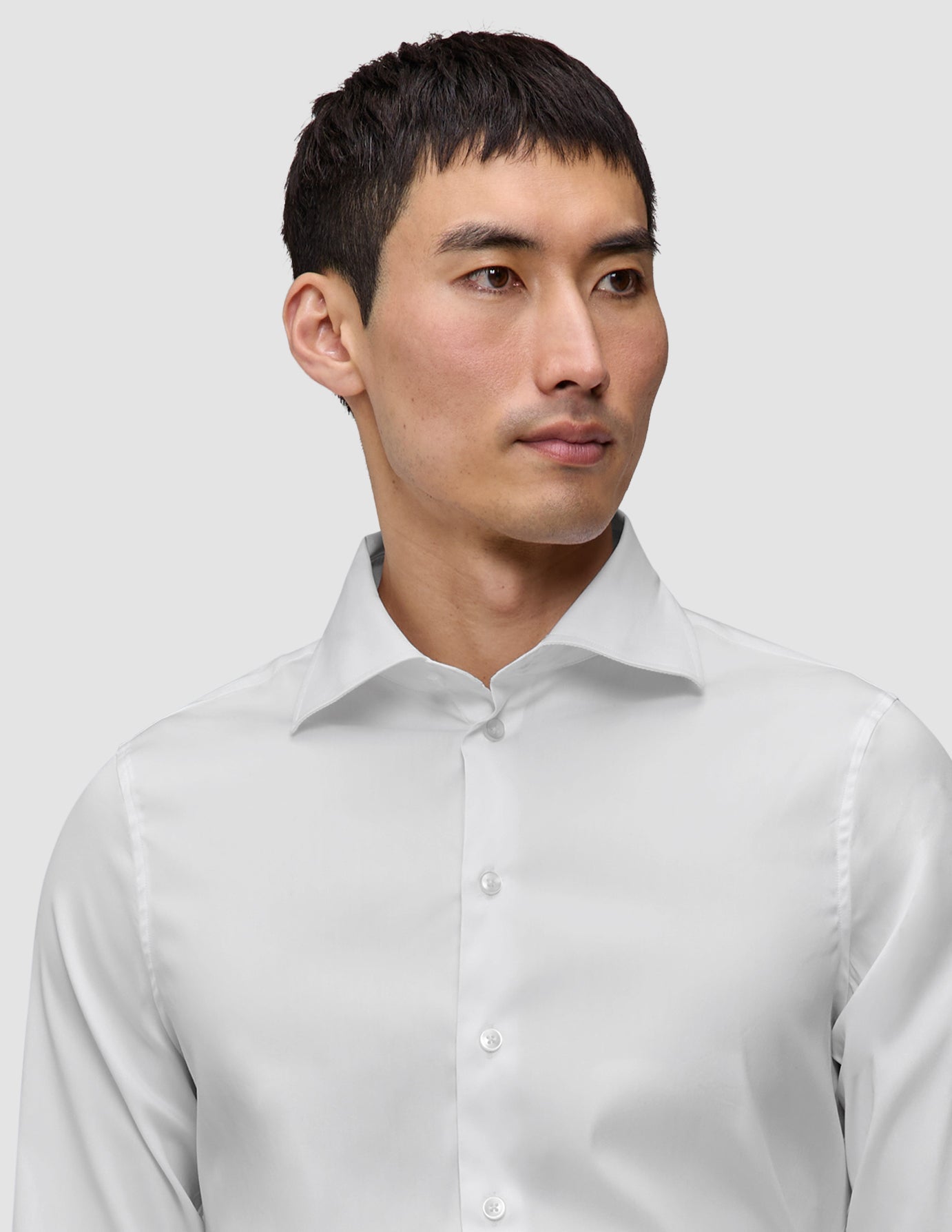 En mann iført en Elevated Shirt White Slim i Pima-bomull, med et hvitt design i smal passform og en spredt krage.