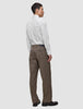 En mann sett bakfra har på seg en hvit, smal Elevated Shirt som er stappet ned i brune bukser og mørke skinnloafers.