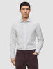 En mann kledd i en Elevated Shirt Slim Light Grey Striped-skjorte med knapper og mørke bukser.